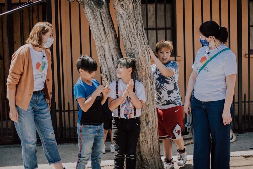 Voluntarias y niños conversando en la calle